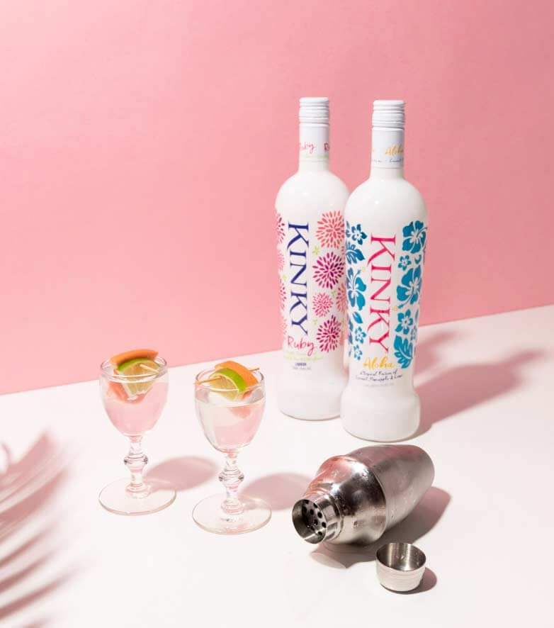 kinky-cocktails decorated with lime and orange and 2 bottles