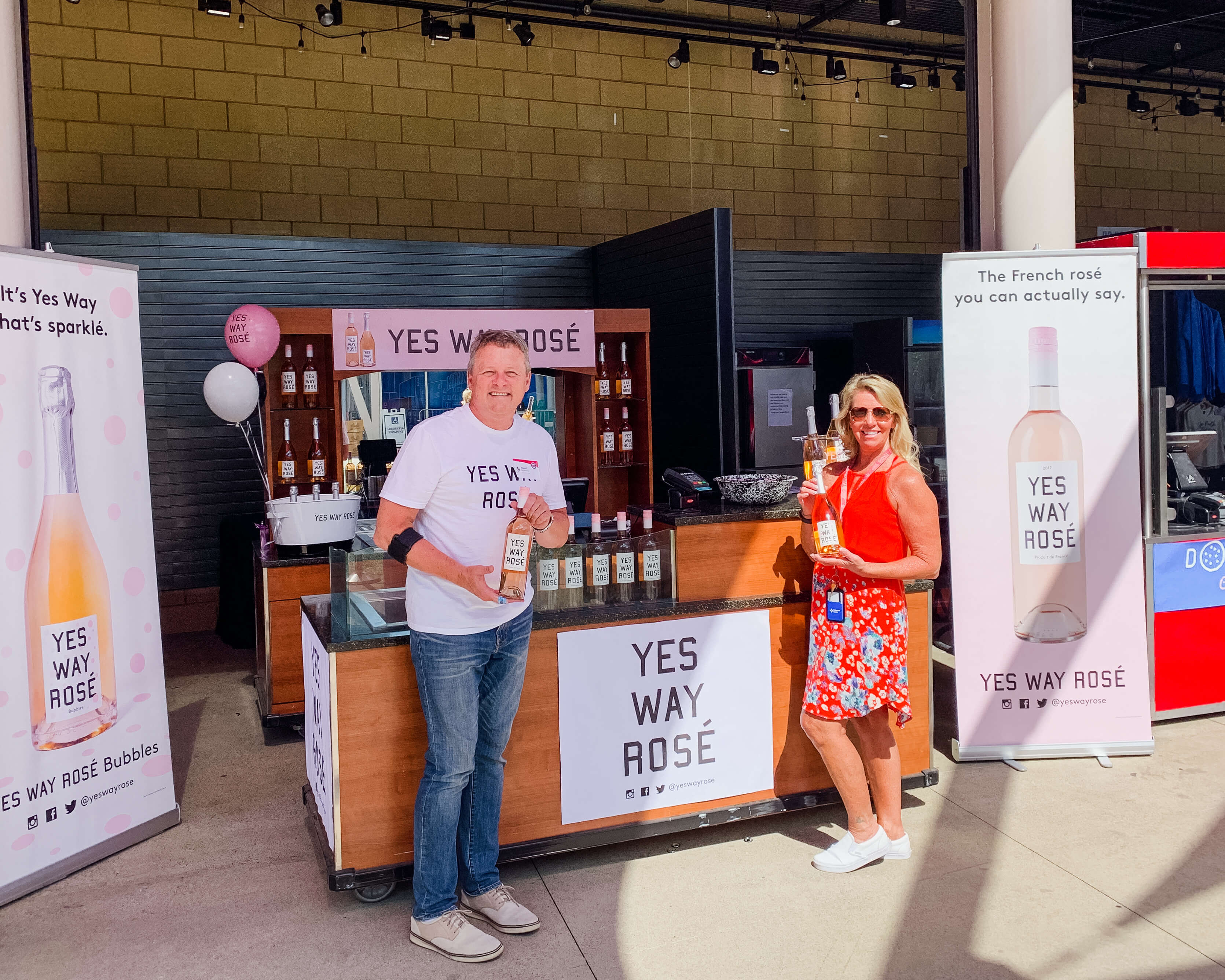A section for yes way rose and 2 people holding 2 ywr bottles