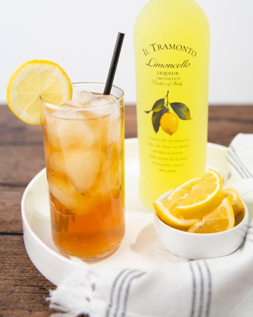 Il Tramonto Limoncello Bottle and a drink of it full of ice and decorated with lemon
