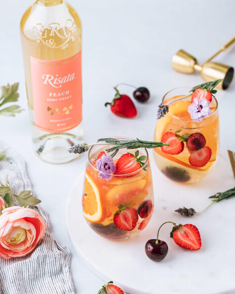 Risata - Peach Sangria garnished with strawberries and a bottle of Risata Peach on the side